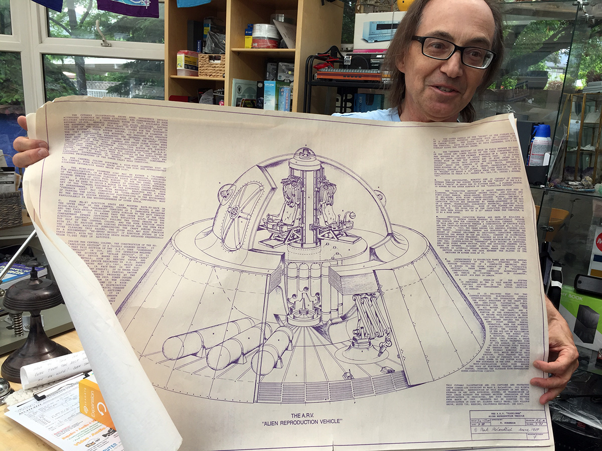 Mark holds up a schematic of an alien spacecraft.