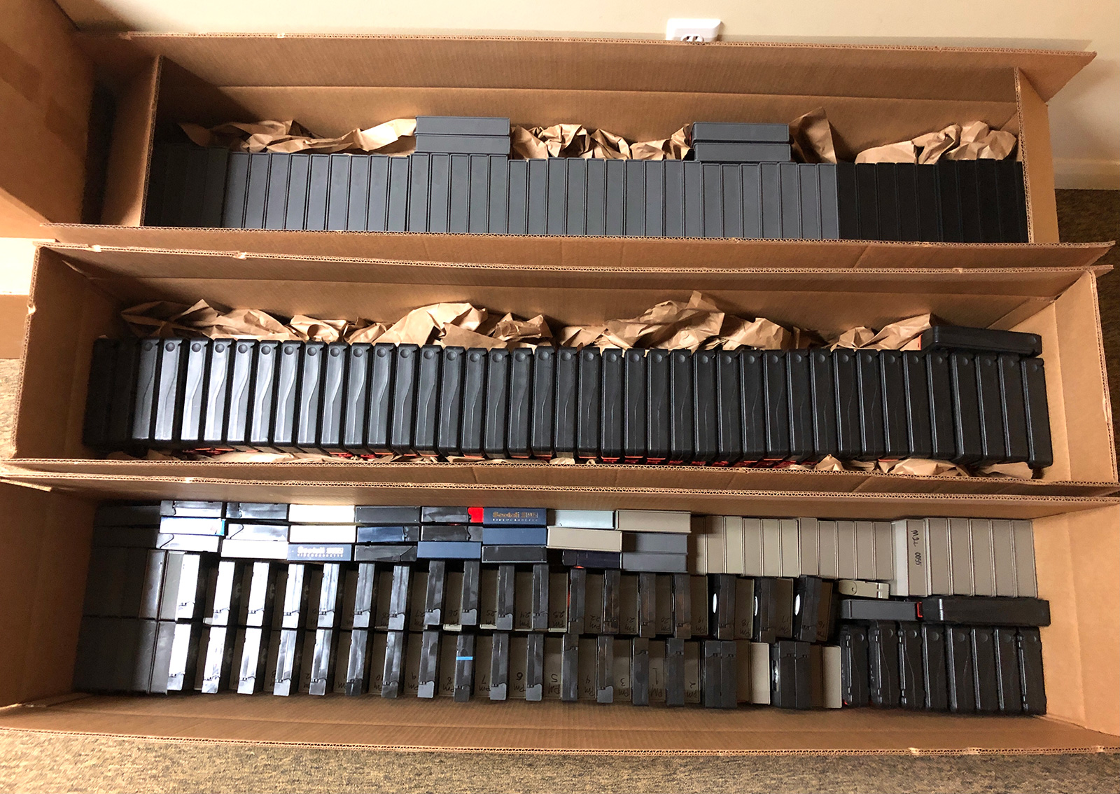 Boxes containing Tex Murphy video tapes. Three long boxes filled with many cassette tapes.
